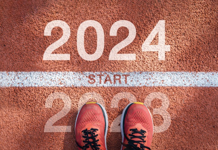 someone stands, wearing trainers, at a race start line labelled 2024